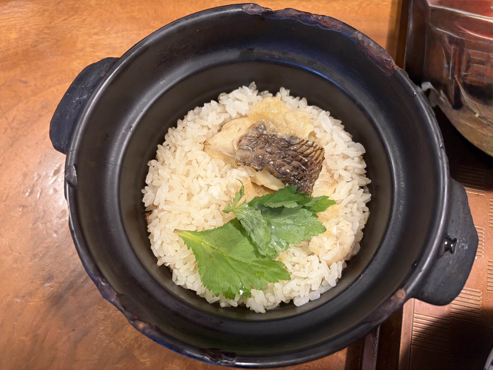 秋嘉の松山鯛めし。土鍋を開けた、鯛と三つ葉がのった炊き込みご飯