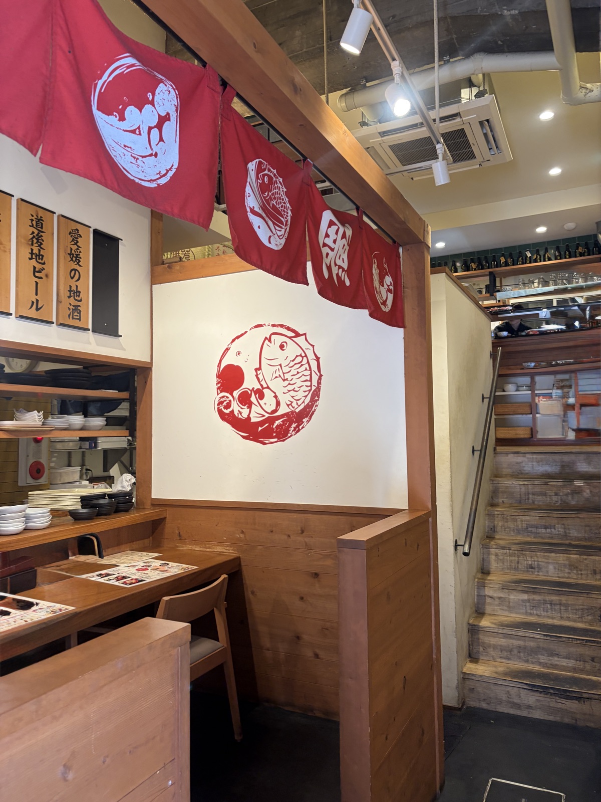 秋嘉の店内。鯛をあしらった赤い暖簾と和の落ち着いた空間