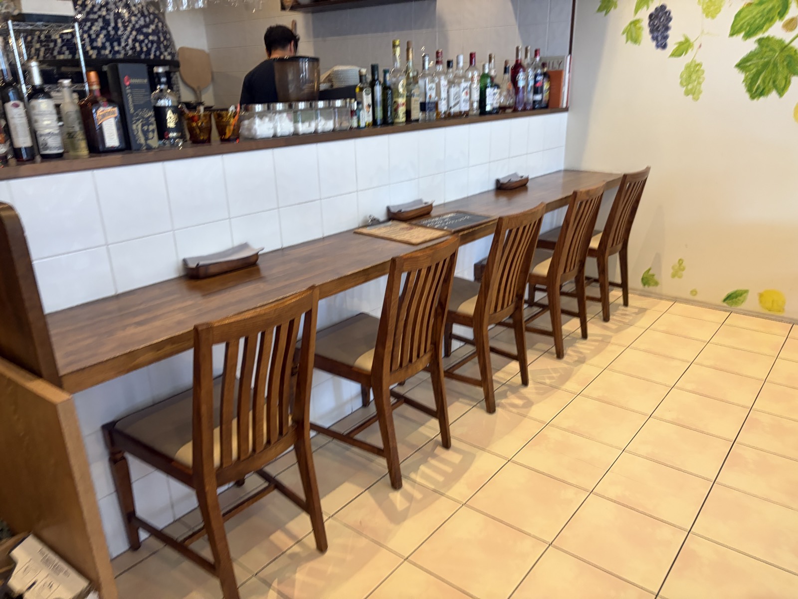 PIZZERIA dodoのカウンター席。木製の椅子が5席並び、一人でも入りやすい