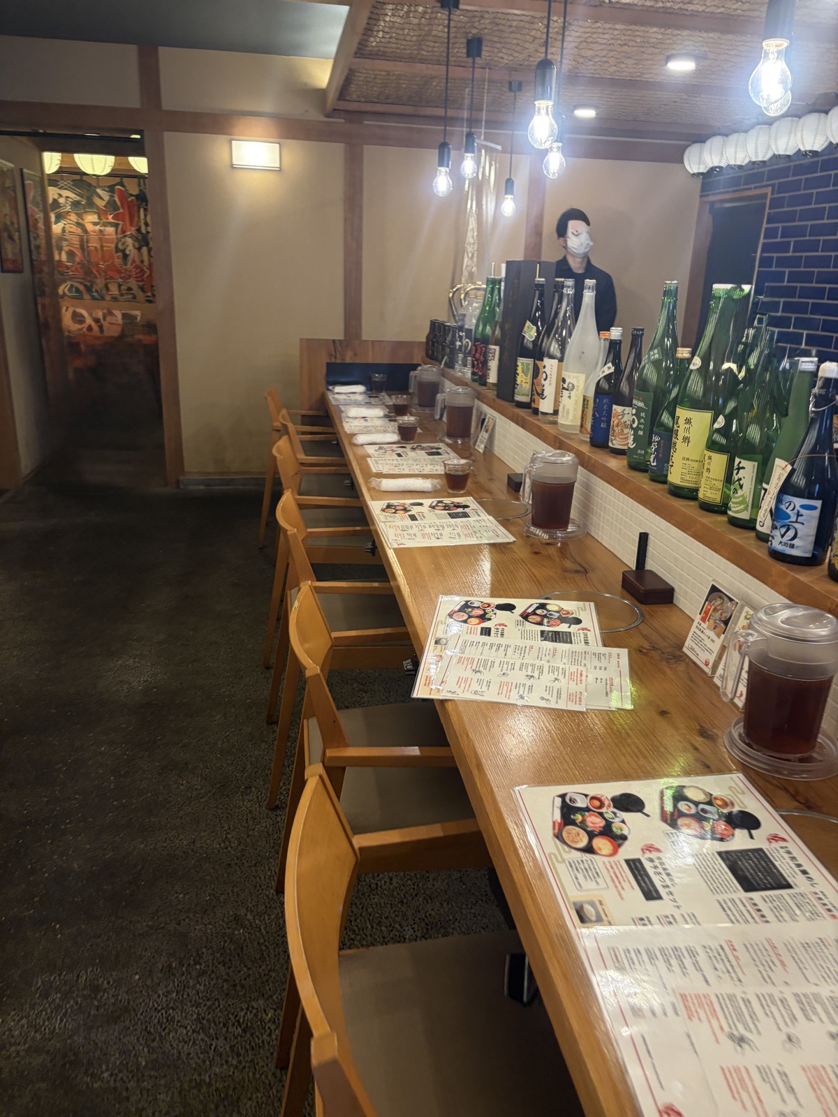 丸水のカウンター席。日本酒の瓶が並ぶ和の空間