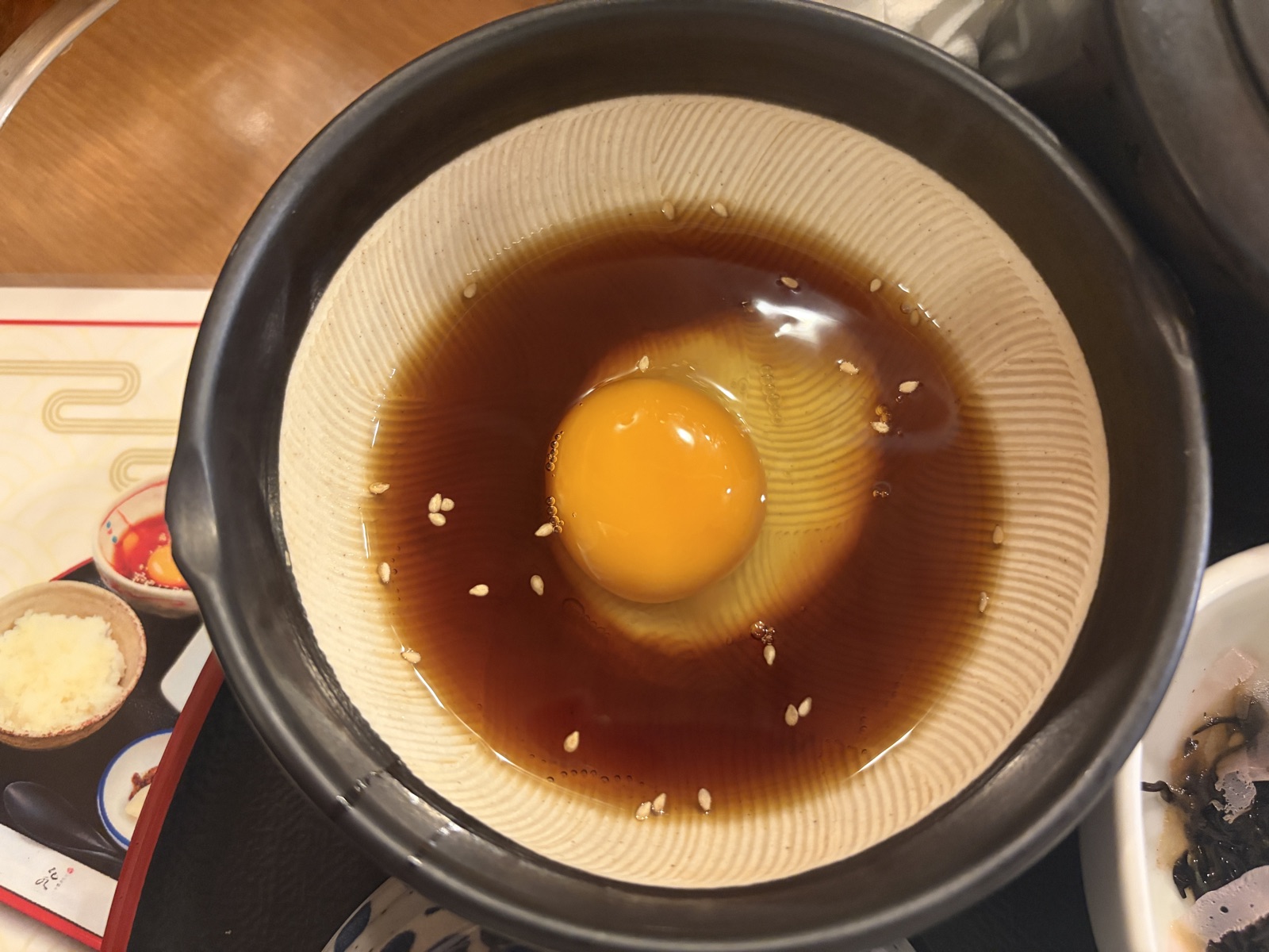 丸水の宇和島鯛めしの食べ方。出汁の器に生卵を割り入れたところ