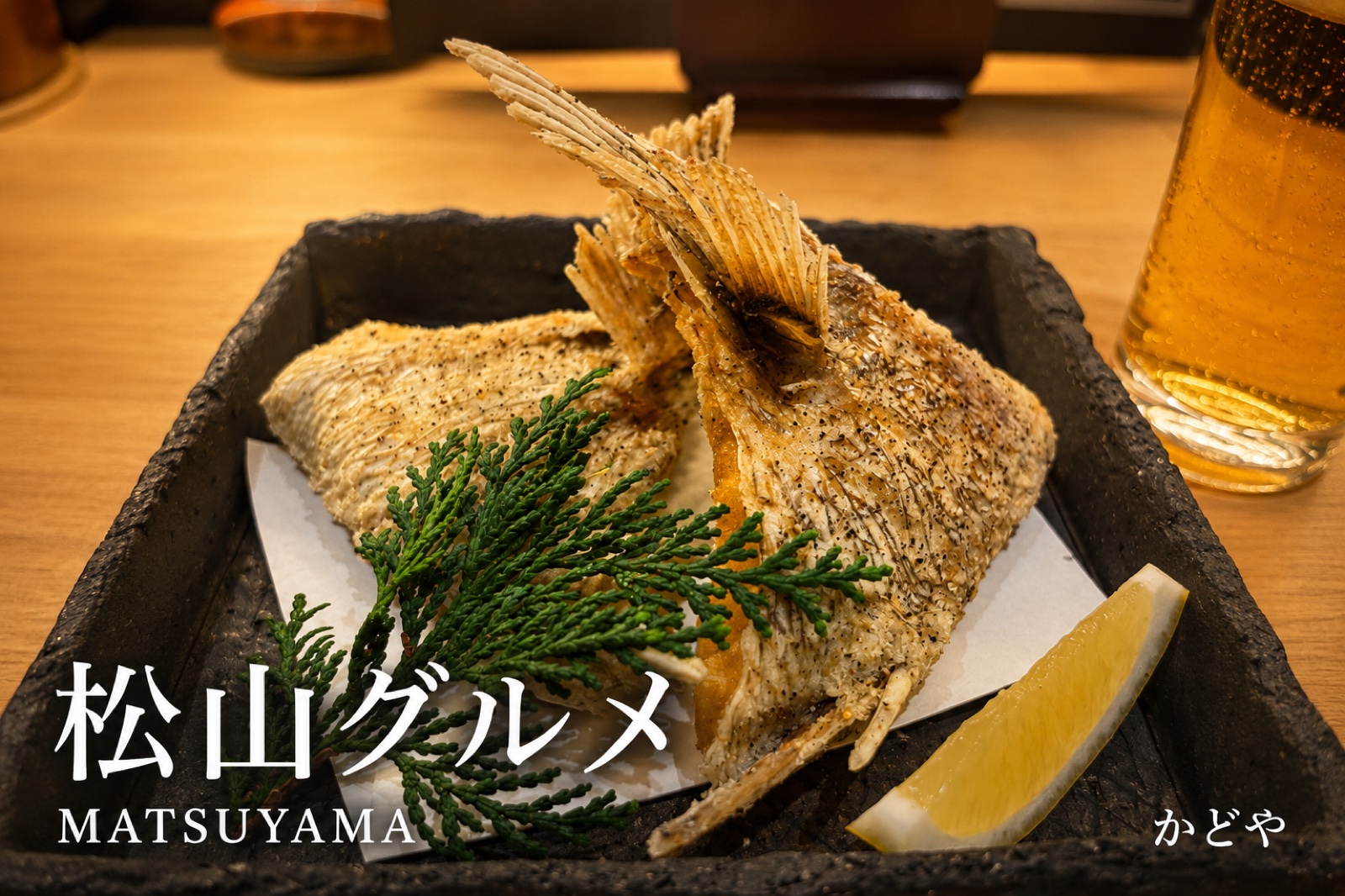 かどやの鯛カマ唐揚げ。石の器に盛られた、こんがり揚がった鯛のカマ