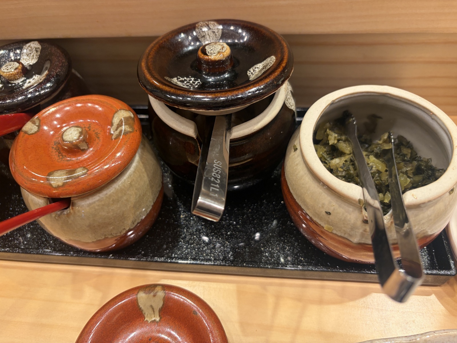 道後天ぷらご天の卓上に並ぶ明太子・海苔の佃煮・大根の漬物・高菜・鮭