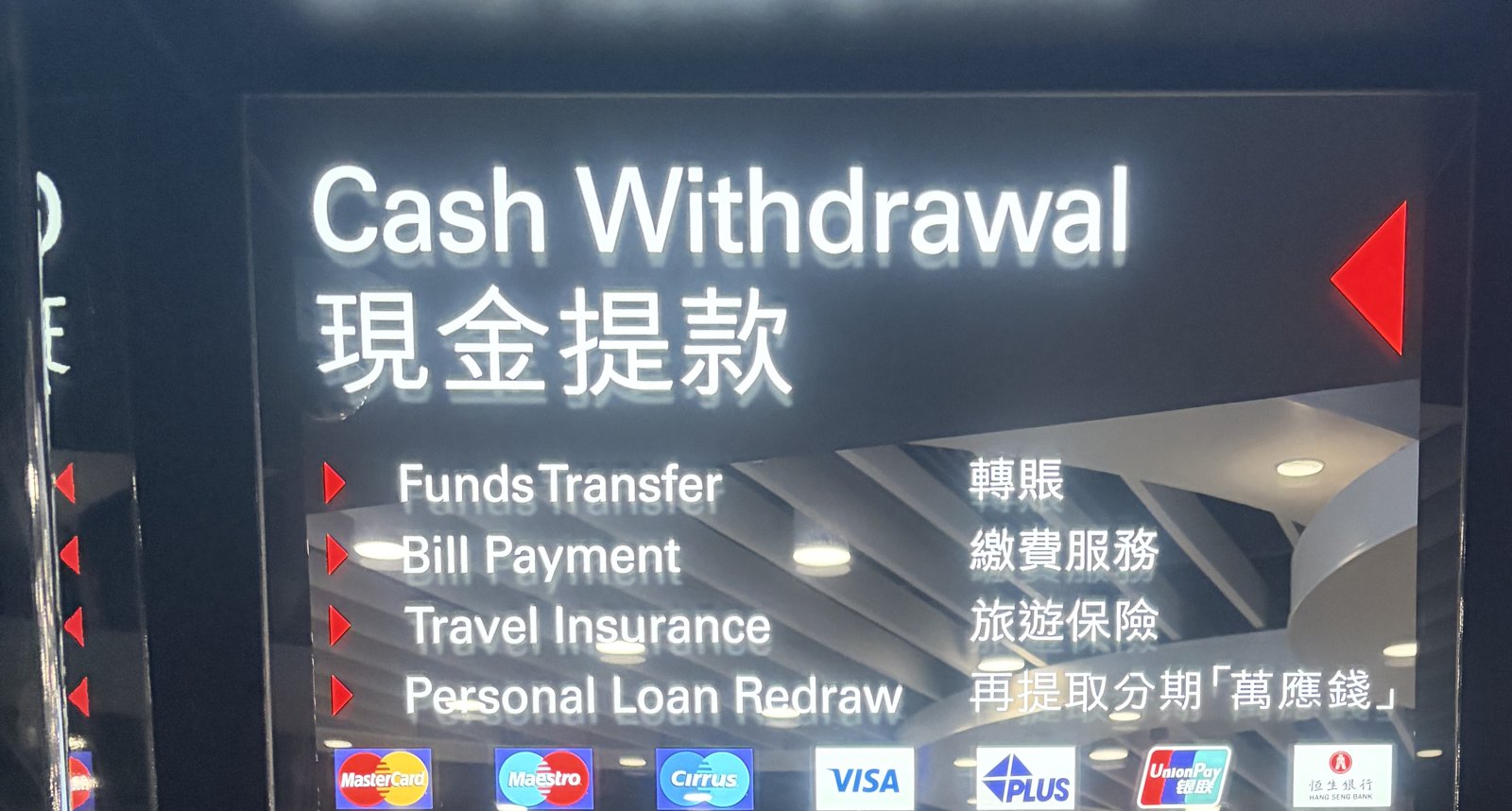 ATMの上の看板。「Cash Withdrawal 現金提款」の下に、Visaなどのカードのマークが並んでいる