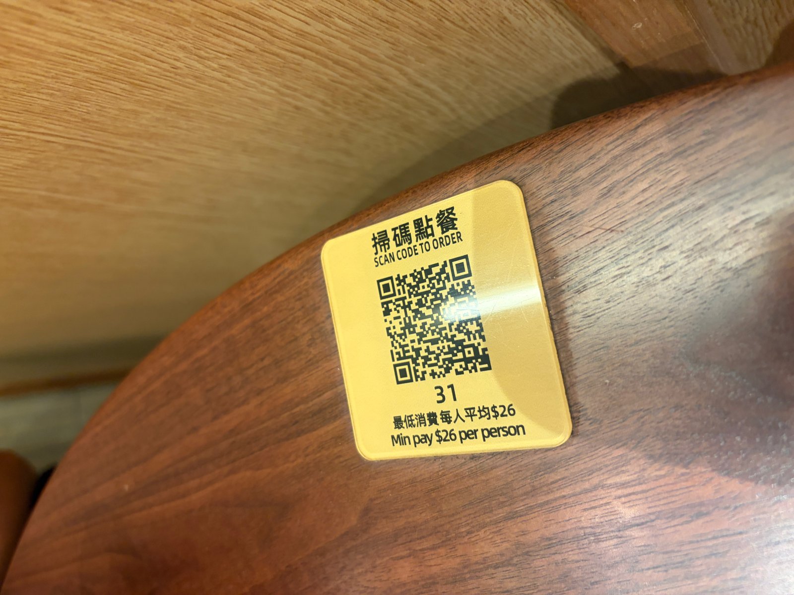 テーブルに貼られたQRコード。「掃碼點餐 SCAN CODE TO ORDER」「最低消費毎人平均$26 Min pay $26 per person」