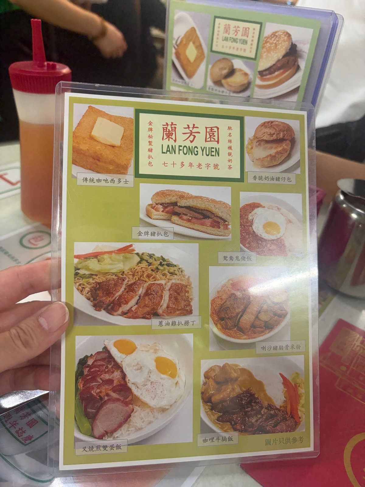 料理のメニュー。左上に、バターがのったフレンチトーストの写真と「傳統咖吔西多士」の文字
