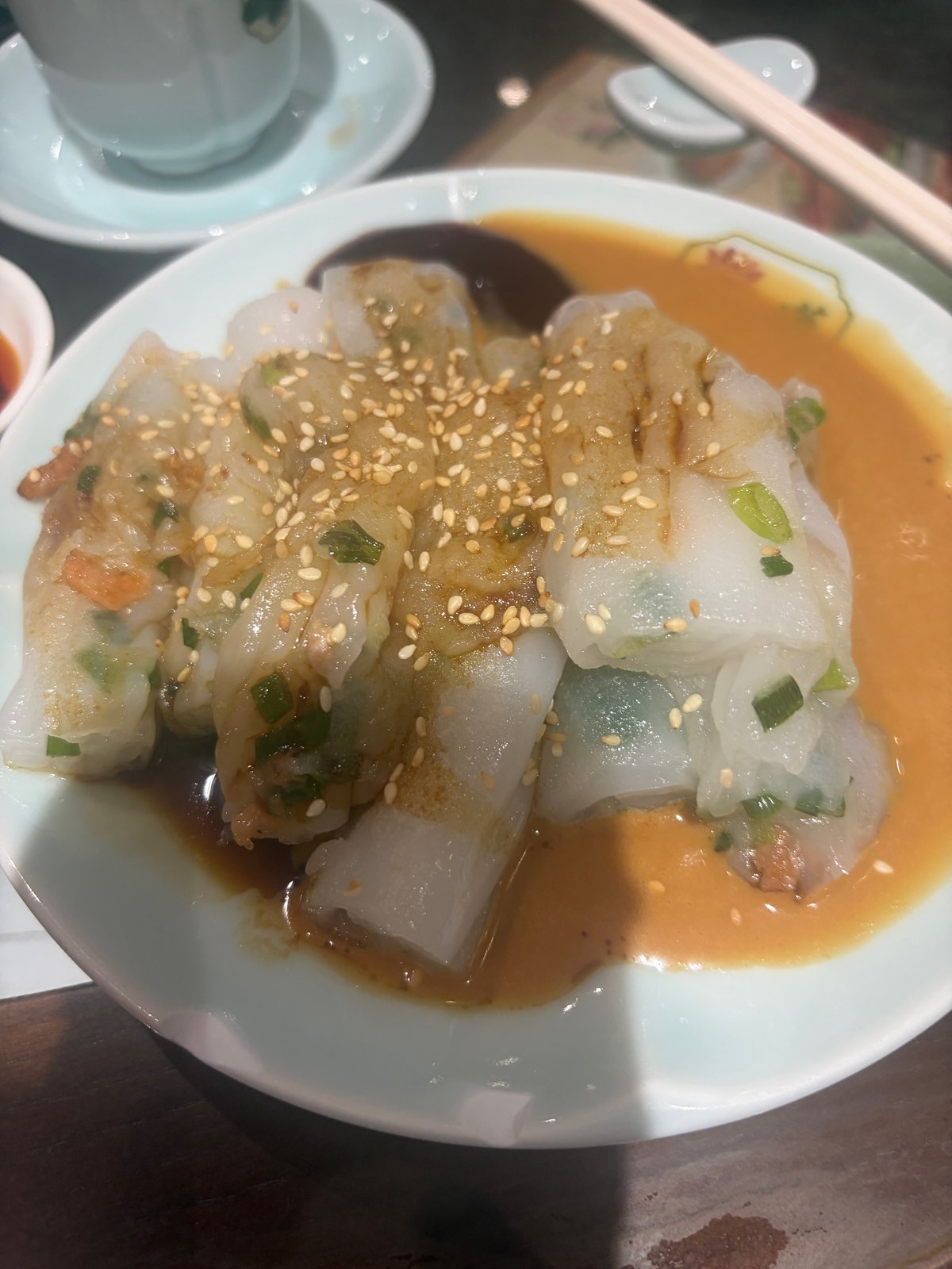 お皿にのった、焼いた点心。ごまと、ごまソース、甘酸っぱいソース、しょうゆがかかっている