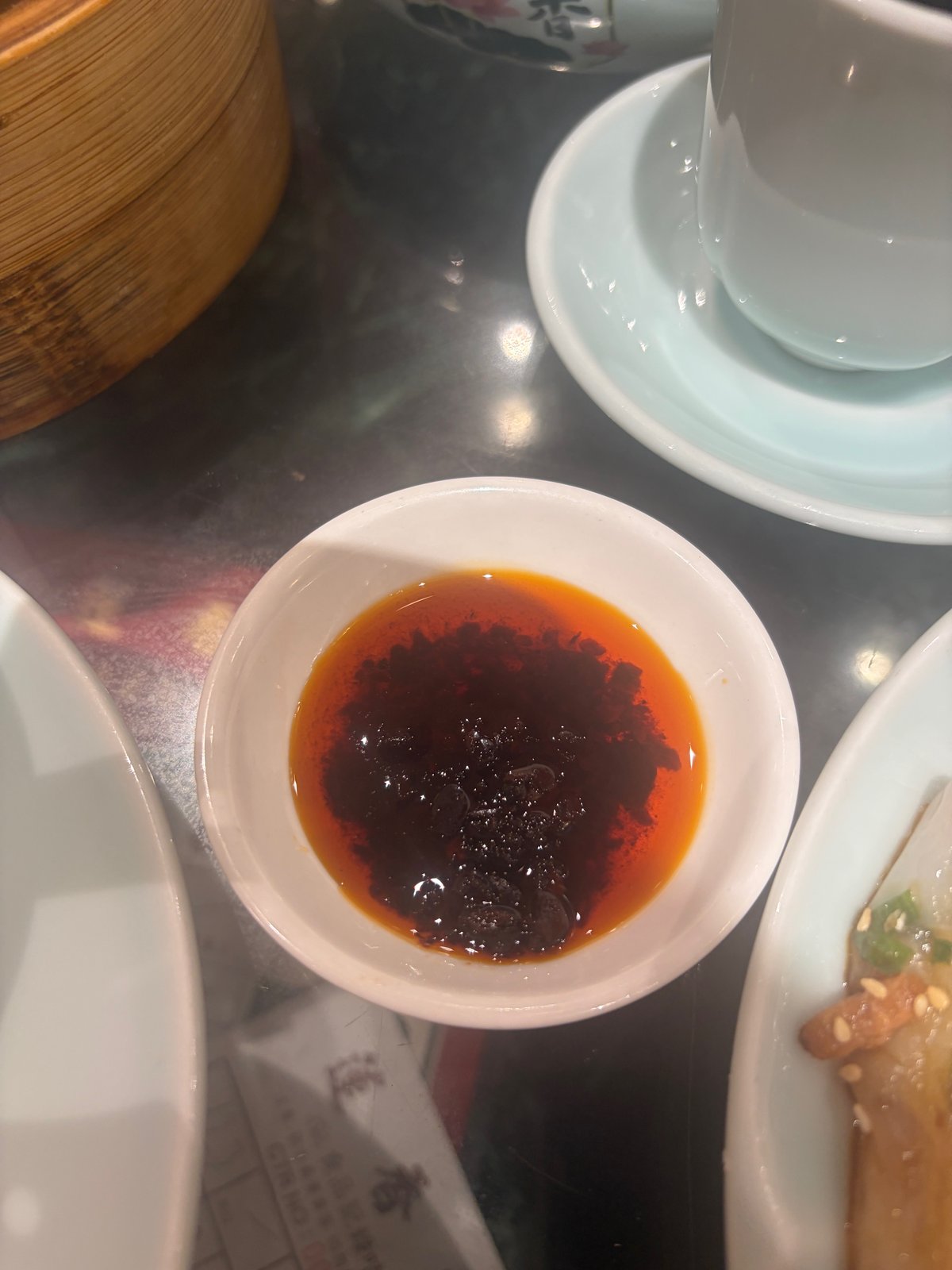 小皿に入ったラー油。赤い油の下に、黒っぽい具が沈んでいる