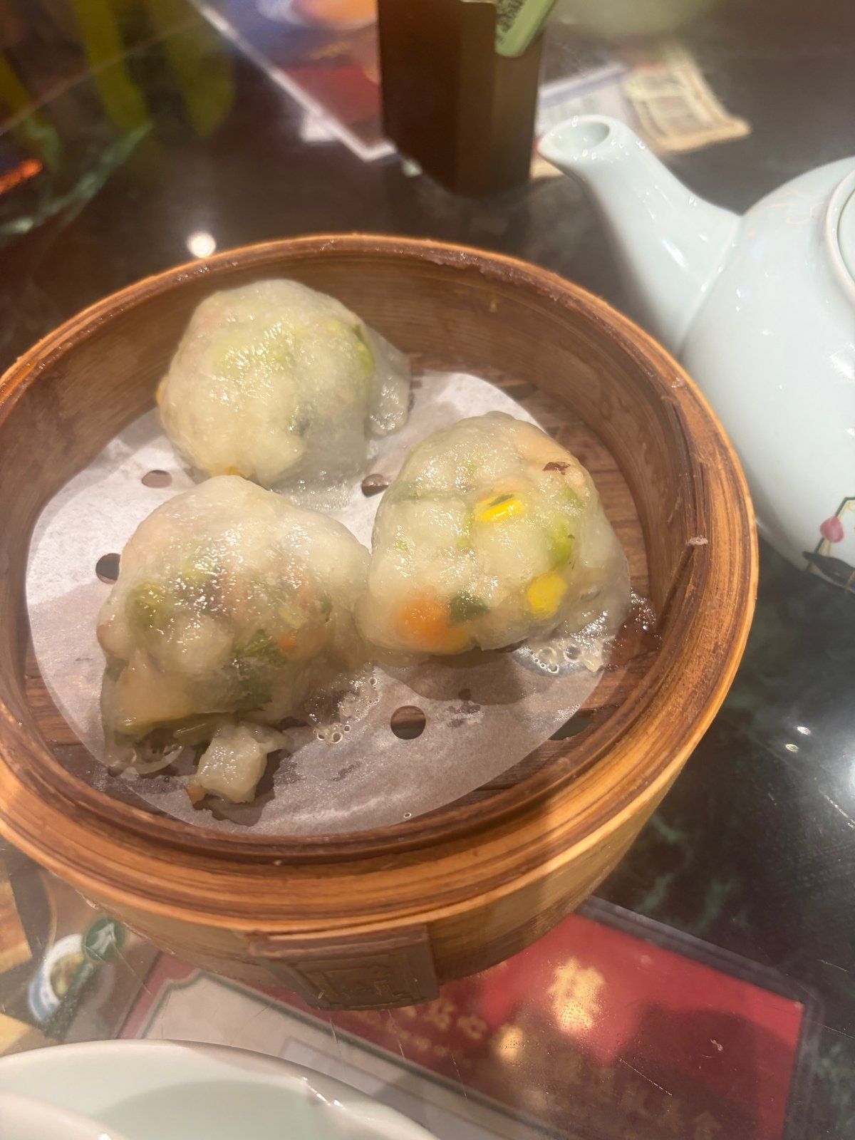 せいろに並んだ、緑や黄色の具が透けて見える蒸し餃子